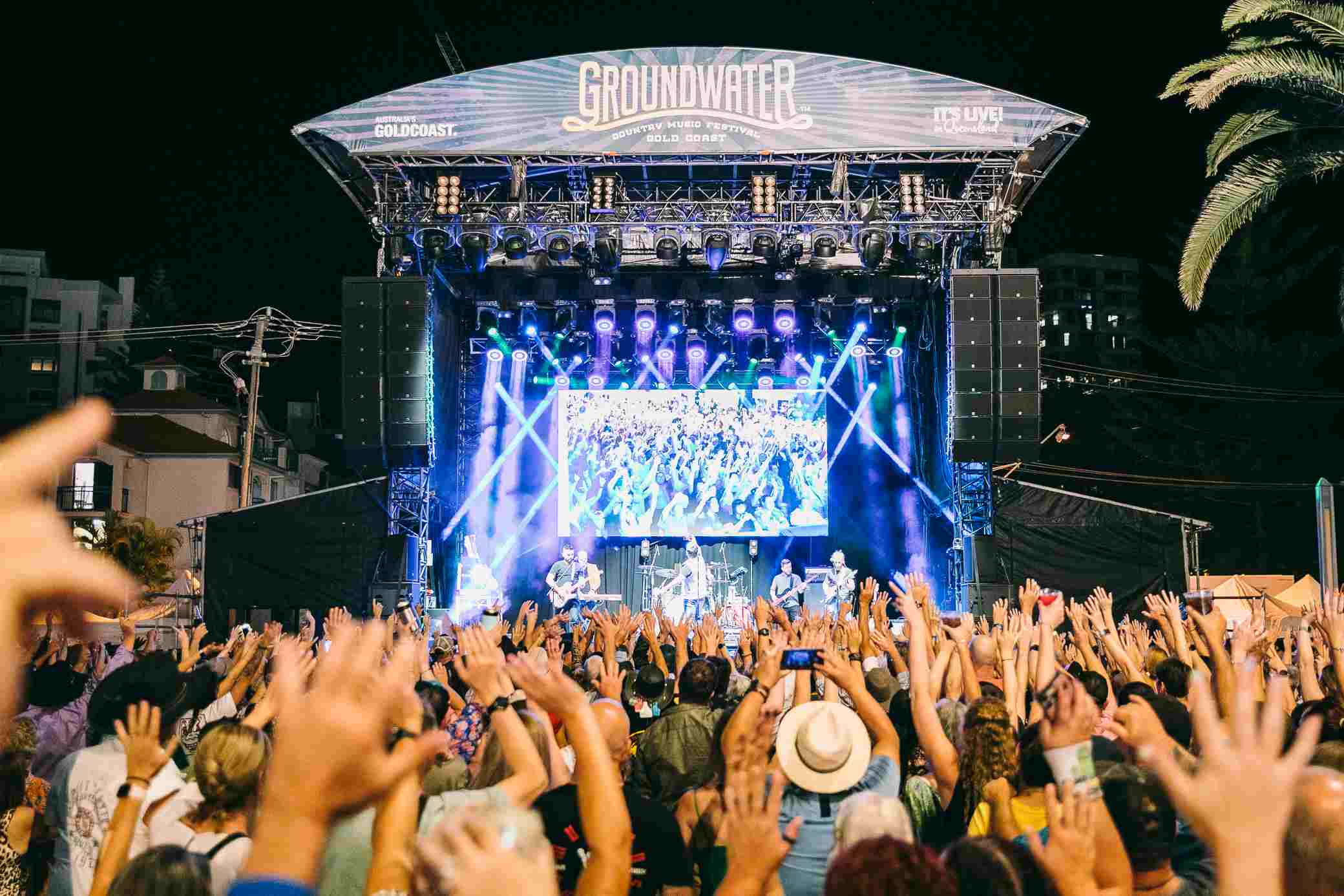 Crowds enjoy a live performance at the Gold Coast Country Music Festival, a highlight of Gold Coast entertainment with vibrant lights, energetic music, and a lively outdoor atmosphere.